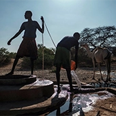 Men extract water from a well at the village of El Gel, near the town of K'elafo, Ethiopia